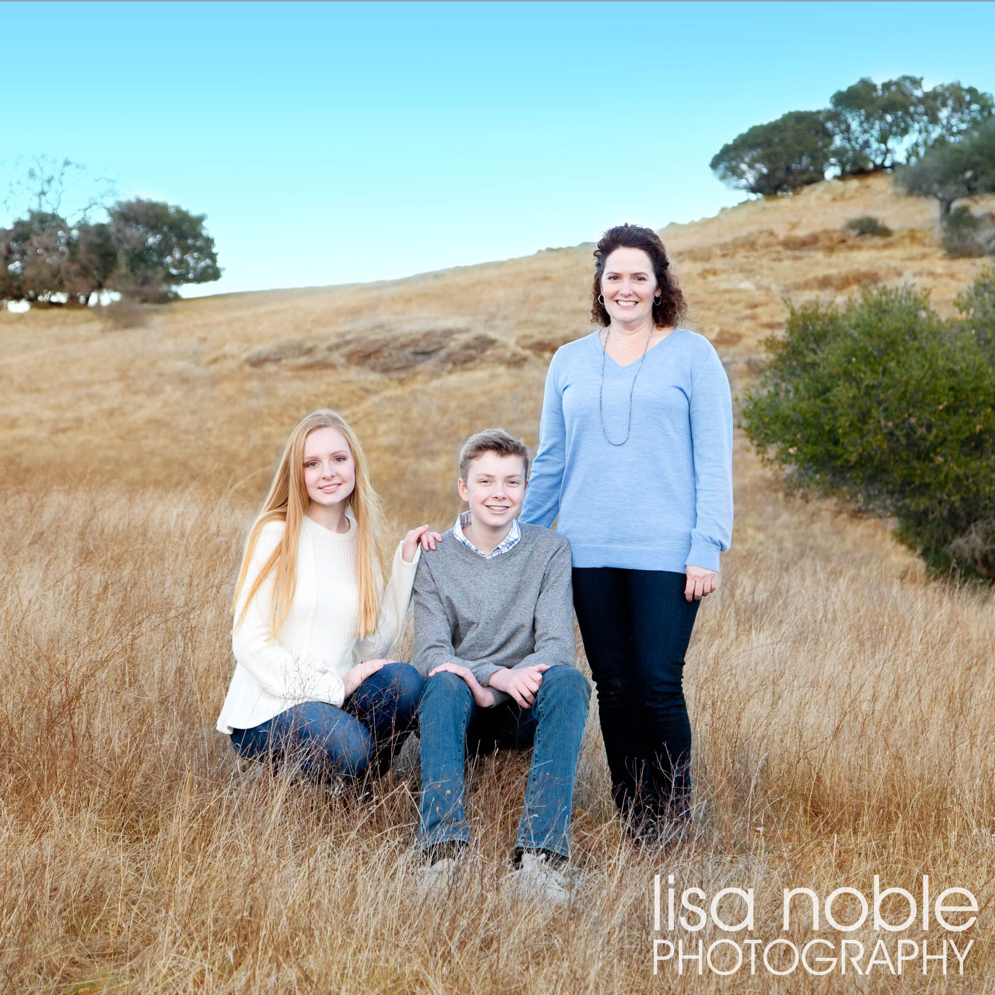 Family portrait in a grass field by Bay Area professional photographer