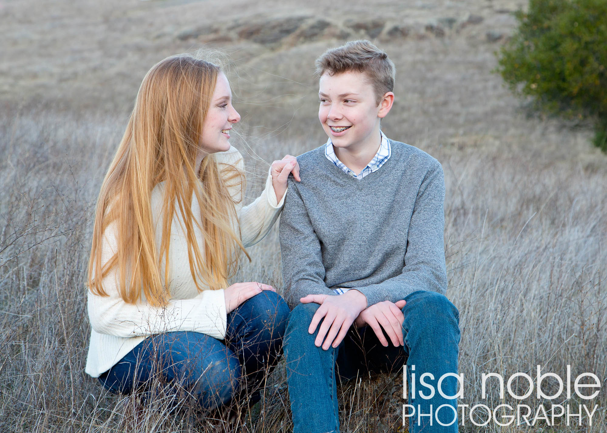 Portrait of siblings in a grass field by Bay Area professional photographer