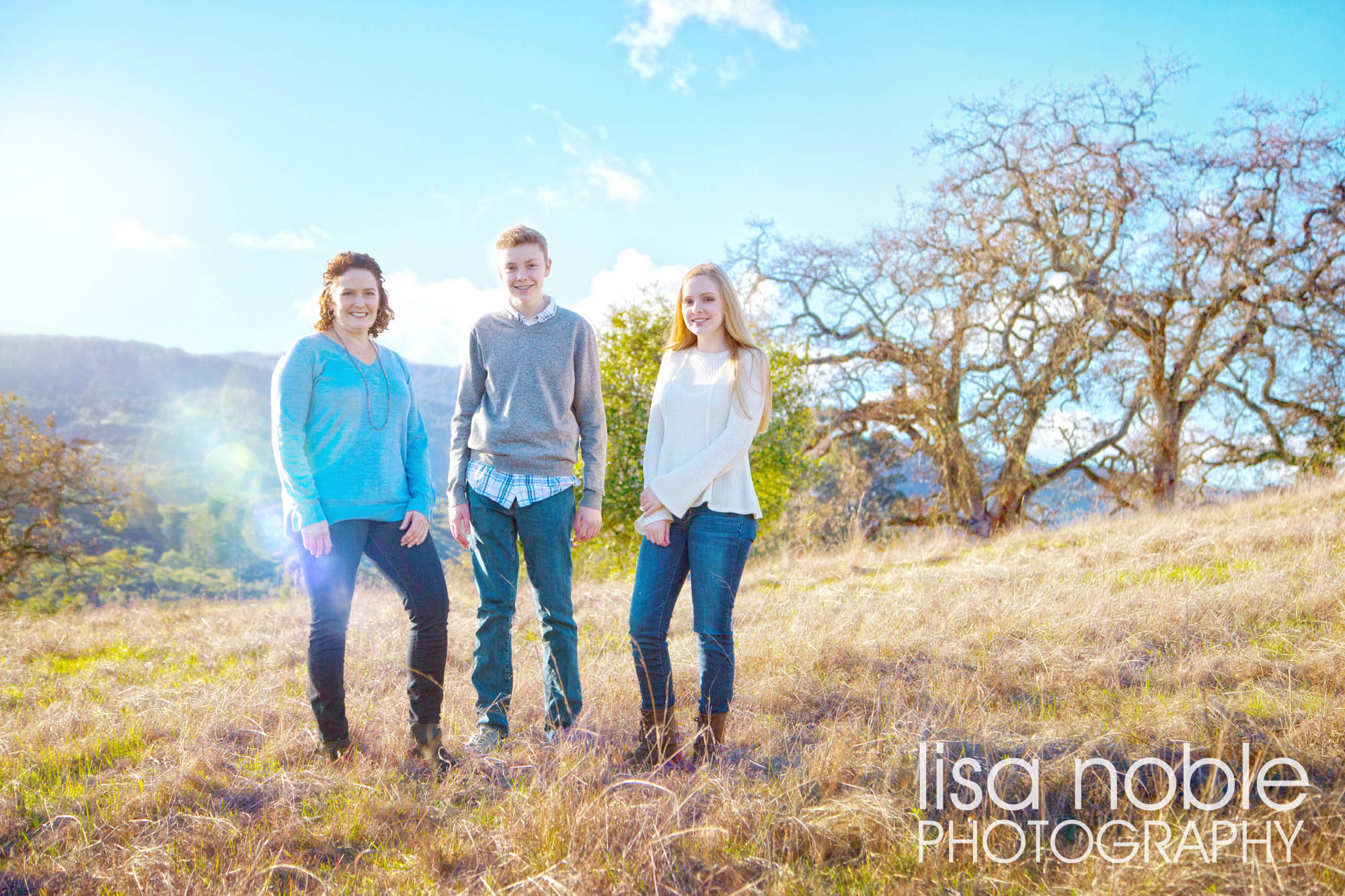 Family portrait in a grass field by Bay Area professional photographer Lisa Noble
