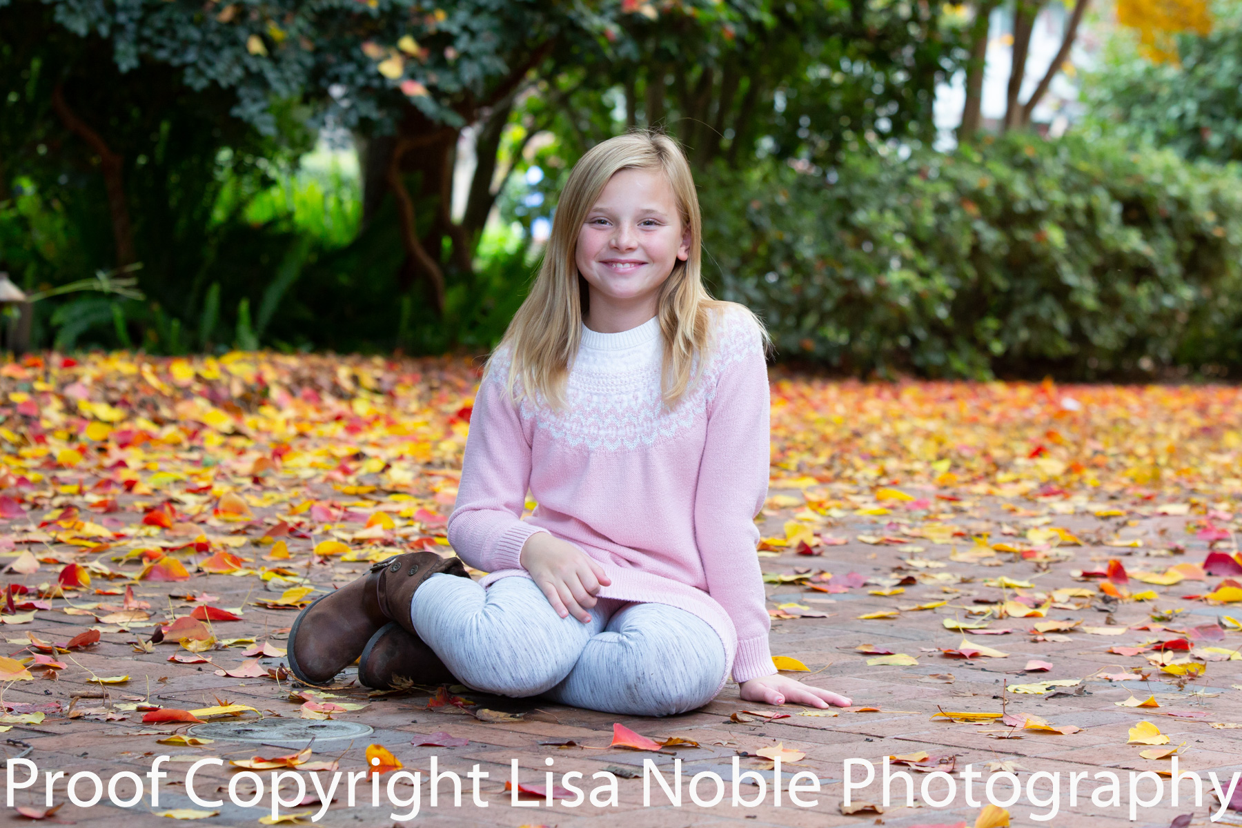 Girl sitting in leaves at photogaphy session